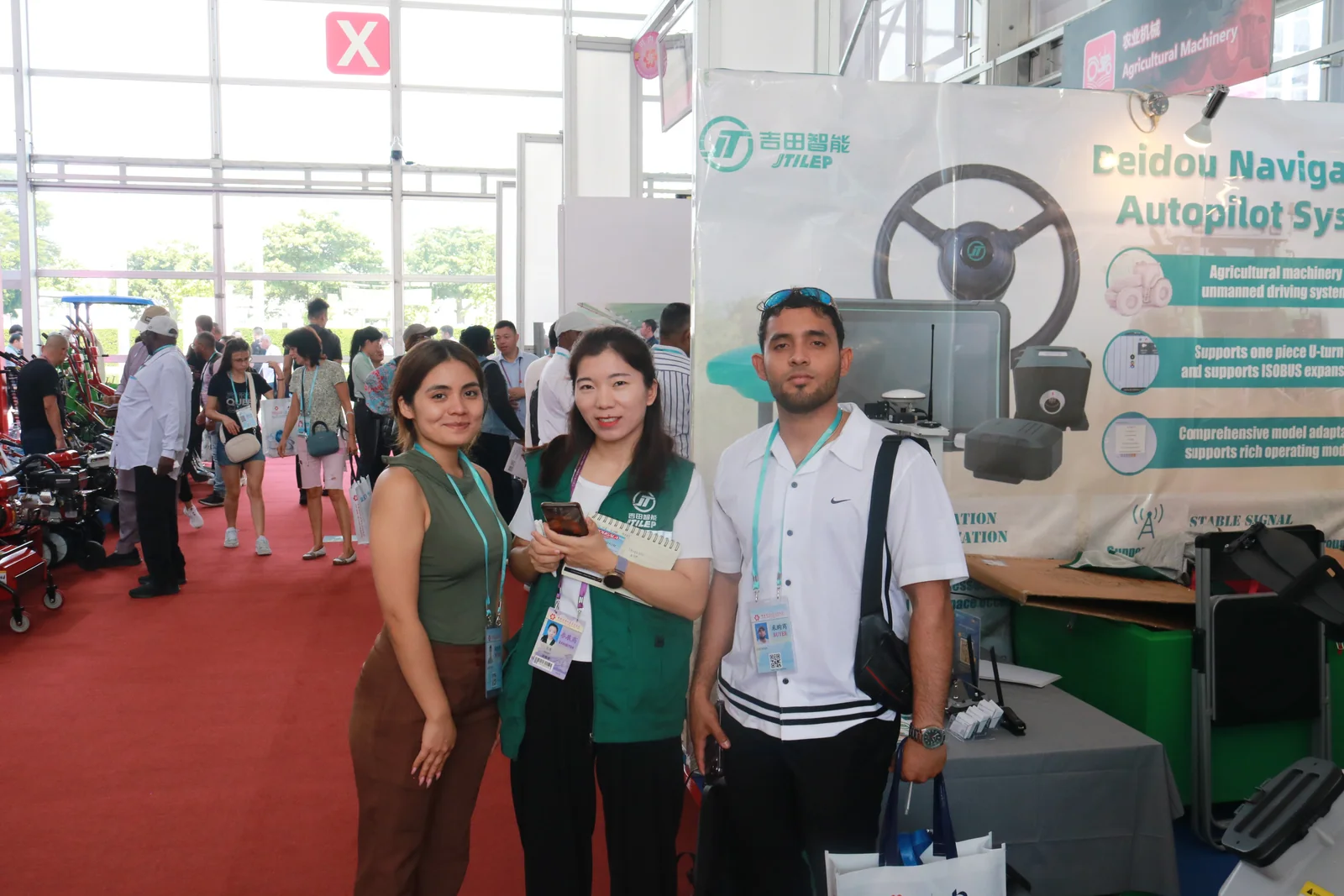 Jitian Intelligent staff with visitors at the company booth during an agricultural machinery exhibition